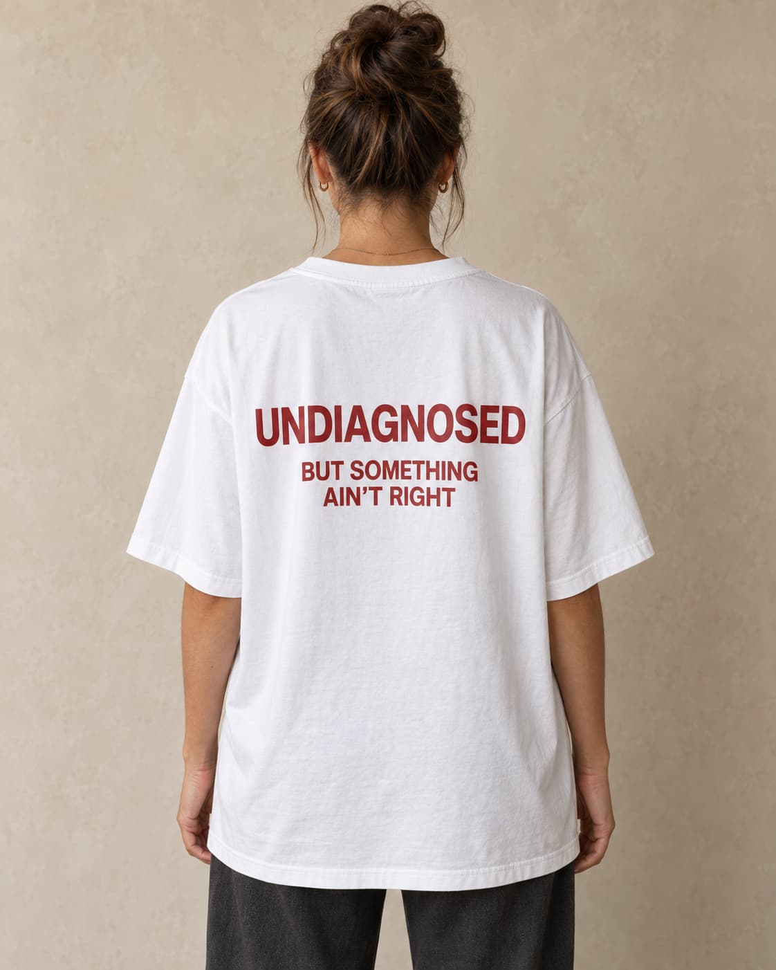 Oversized Tee in white. Caption reads: UNDIAGNOSED BUT SOMETHING AIN’T RIGHT